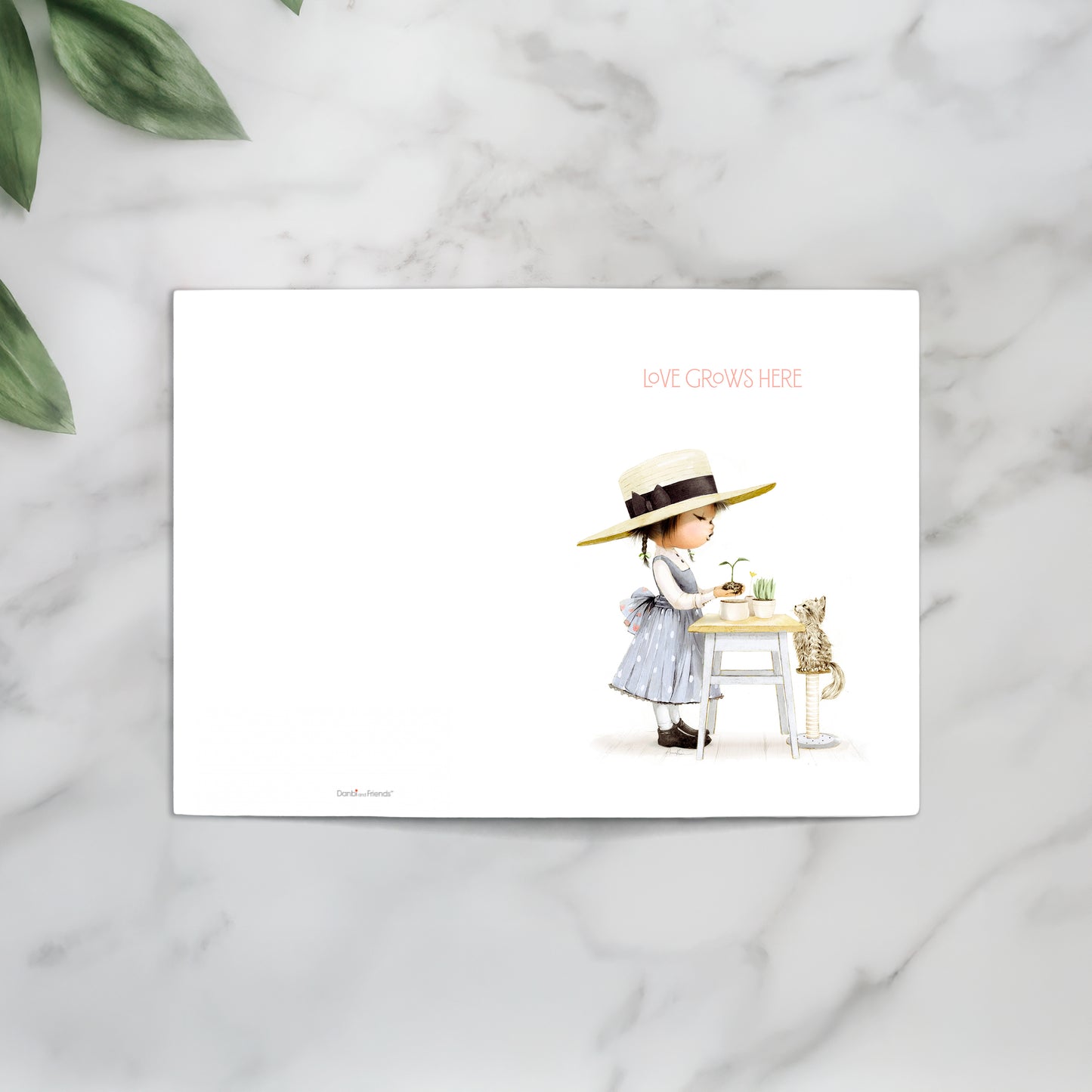 Greeting card with illustration of a girl in a hat and dress, sitting at a table with a cat on a marble surface.