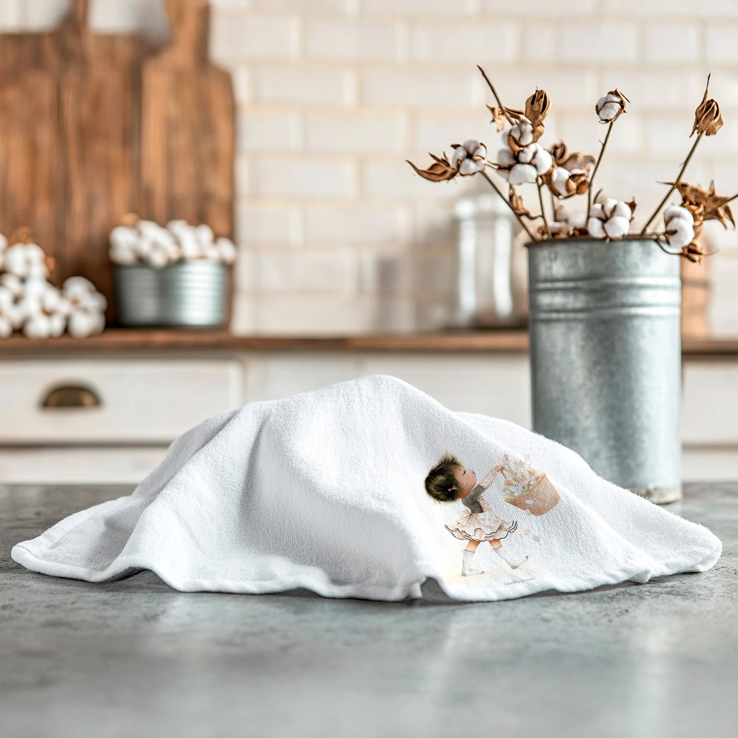 White towel with a little girl design on a kitchen counter