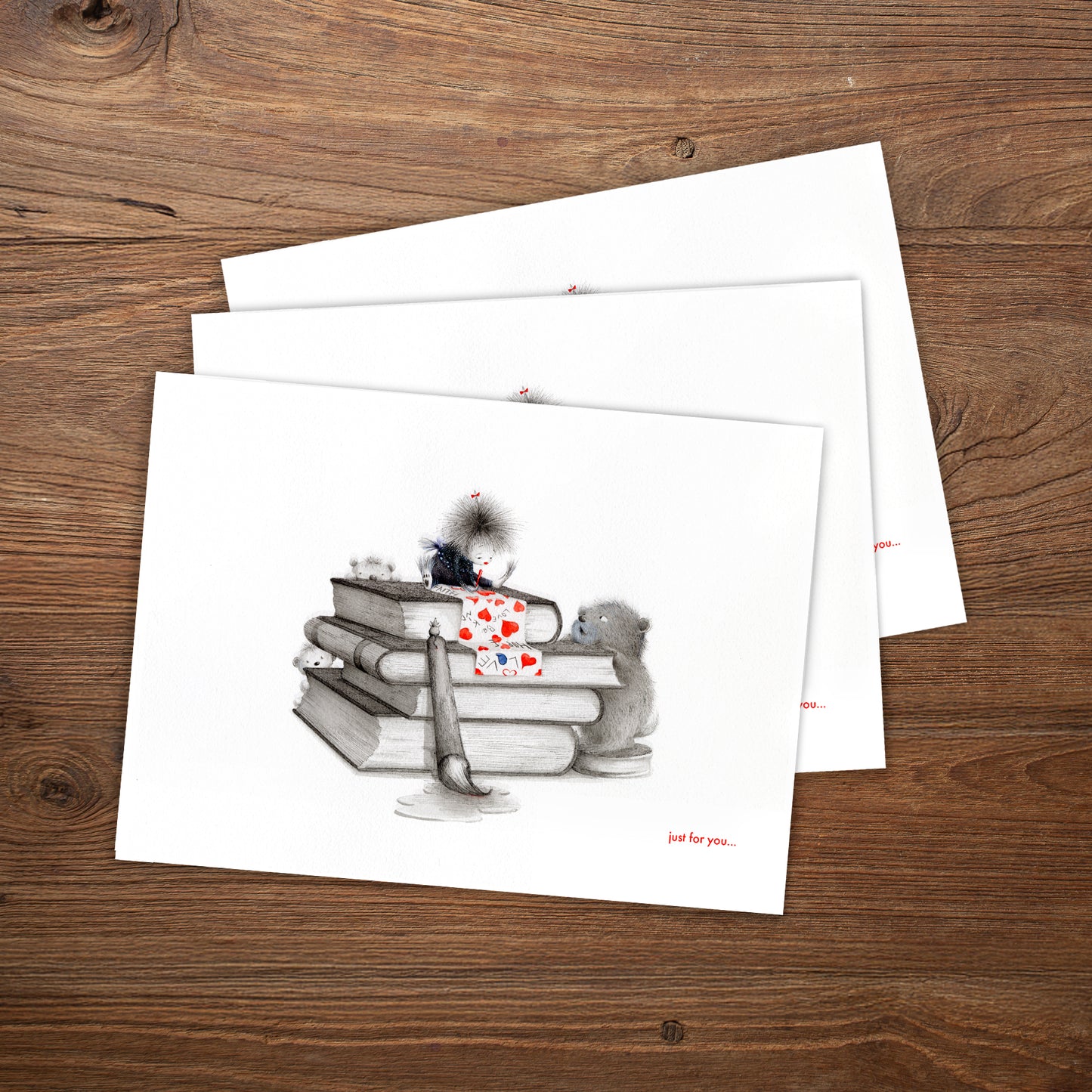 Set of greeting cards with a design of books and hearts on a wooden surface