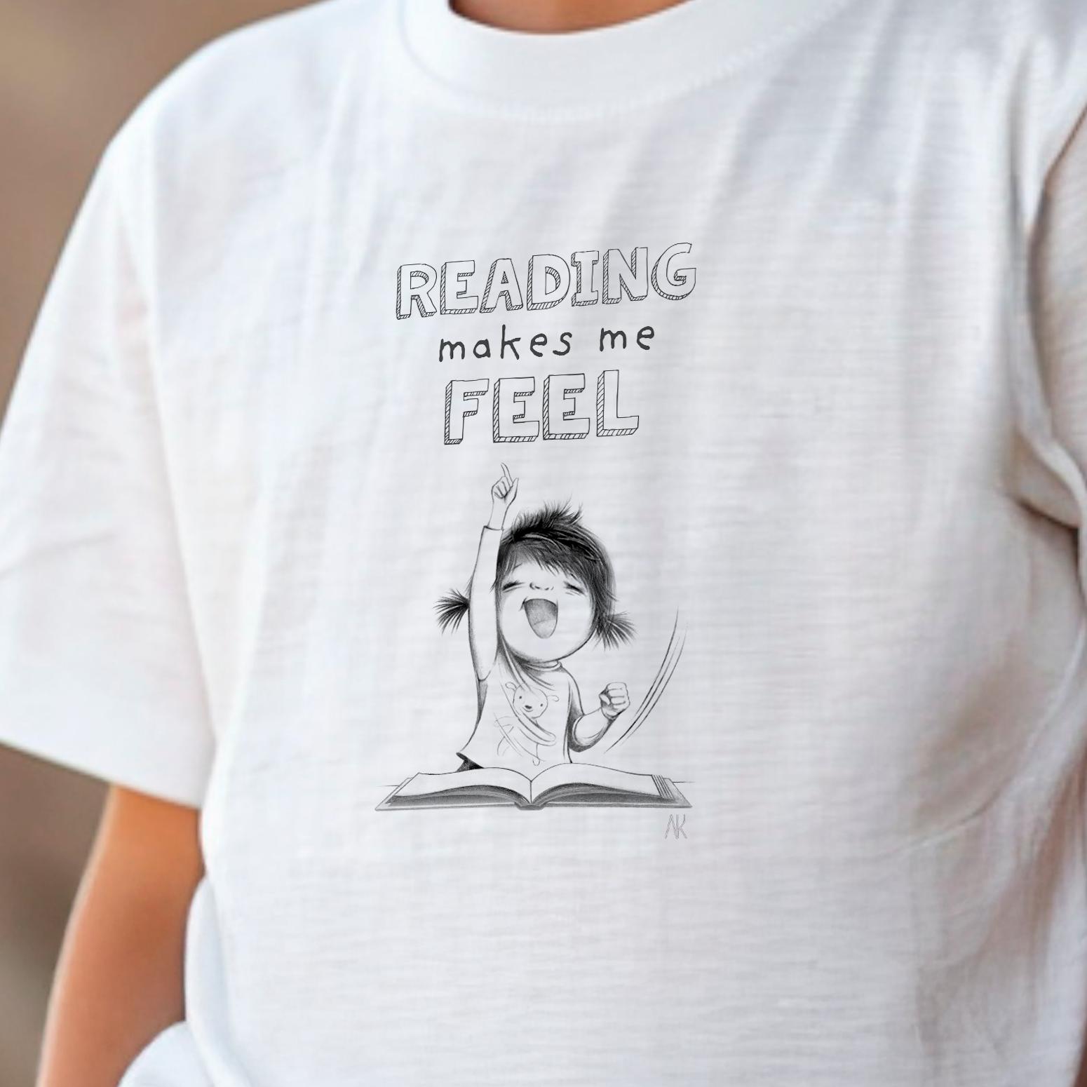White t-shirt with a cartoon character and 'Reading makes me feel' text on a blurred background